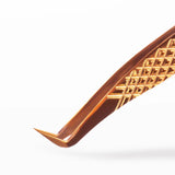 Close-up of Gold Boot Volume Tweezers with a textured surface on a white background