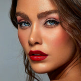 Close-up of a woman with red lipstick against a neutral background