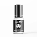 Eyelash adhesive bottle with black and white design on a white background