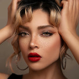 Woman with red lipstick and hoop earrings against a neutral background